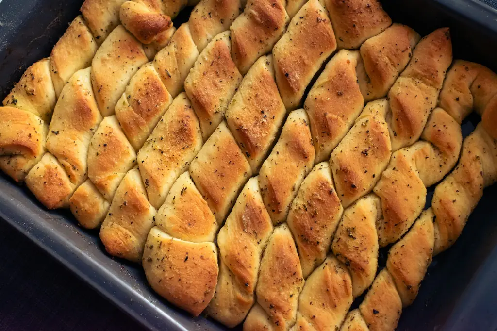 Goldbraun gebackene Brötchen dicht an dicht in einer Backform