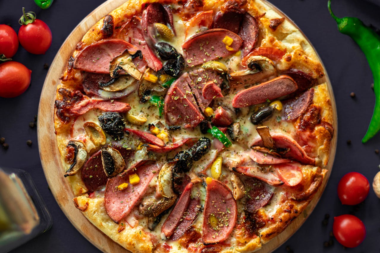Top view of a freshly baked pizza with meat and vegetables, perfect for food photography lovers.