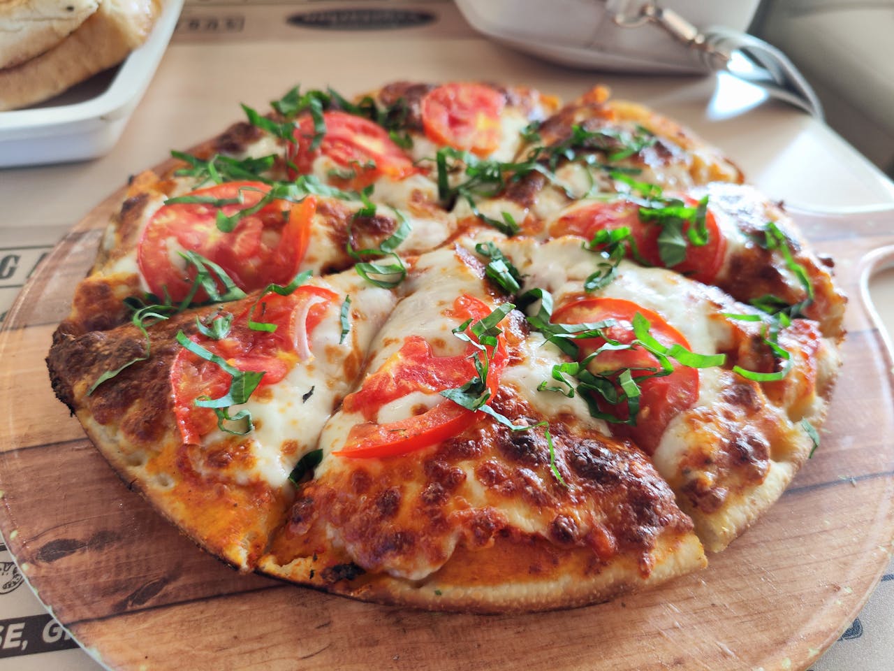 Close-up of a fresh Margherita pizza with tomatoes and basil. Perfect for Italian cuisine promotions.
